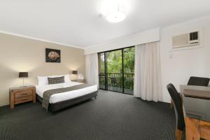 a hotel room with a bed and a window at Mt Ommaney Hotel Apartments in Brisbane