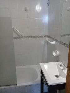 a bathroom with a white tub and a sink at Cabañas Mapuche in Esquel