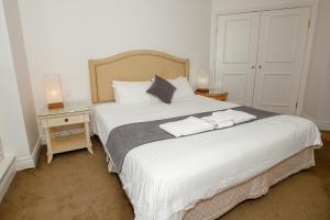 a bedroom with a large white bed with two pillows at Bond 1603 Self Catering in Sydney