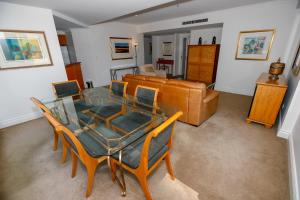 a dining room with a table and chairs and a couch at Bond 1603 Self Catering in Sydney