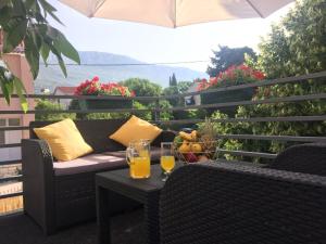 a balcony with a couch and two glasses of orange juice at Sunflower in Kaštela