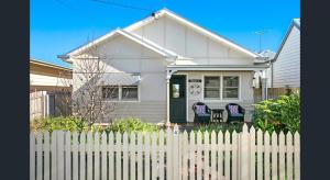 a white house with a white picket fence at Bluey's in Queenscliff