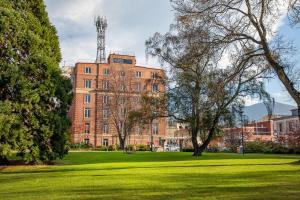 a large brick building in a field of grass at Mantra One Sandy Bay Road in Hobart