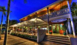 a restaurant with people sitting at tables outside of a building at Sovereign Resort Hotel in Cooktown