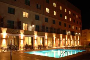 a swimming pool in front of a building at night at Hotel Real Oeiras in Oeiras
