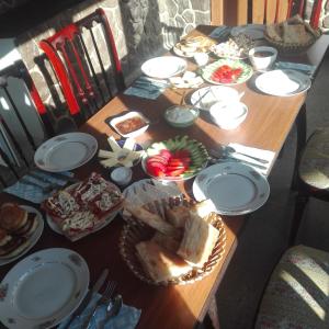 une table en bois avec des assiettes et de la nourriture dans l'établissement Guest House Sabauri, à Kazbegi
