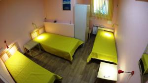 ノヴォシビルスクにあるHostel On-dayの緑色のベッド2台、冷蔵庫が備わる客室です。