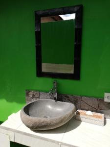 a bathroom with a sink and a green wall at Kakiang Homestay in Nusa Lembongan