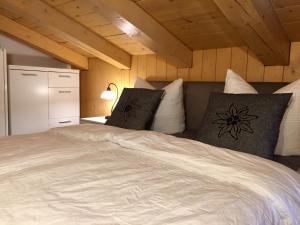 ein Schlafzimmer mit einem großen weißen Bett mit Kissen in der Unterkunft Alpensuite TOP 6 am Wilden Kaiser in Scheffau am Wilden Kaiser