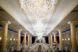 un gran salón de banquetes con mesas blancas y una lámpara de araña en Hotel Ten Constanta en Constanza