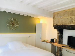 a bedroom with a bed and a stone fireplace at La Maison des Arts, Le Six in Honfleur