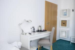 a room with a white desk and a chair at Hotel Inner City in Kutno
