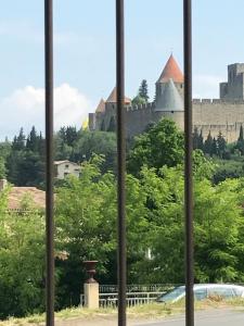 een raam met uitzicht op een kasteel bij L'Orée de la cité in Carcassonne