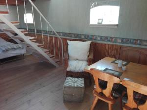 AskebyにあるMoen Oekologisk Bed & Breakfastのテーブルと椅子、階段が備わる客室です。