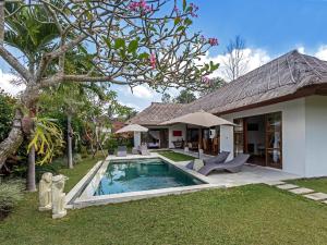 a house with a swimming pool in the yard at Villa Candi Kecil Tiga in Ubud