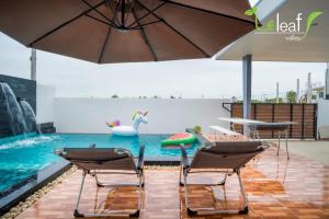 a pool with a swan and chairs and an umbrella at Le Leaf Valley Hua Hin 29 in Hua Hin