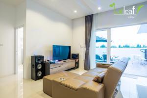 a living room with a couch and a flat screen tv at Le Leaf Valley Hua Hin 29 in Hua Hin