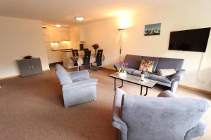 a living room with couches and chairs and a tv at Apartment Azur in Saas-Fee