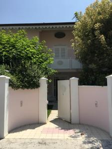una recinzione bianca di fronte a una casa di Villa Amelia Rooms a Marina di Pietrasanta