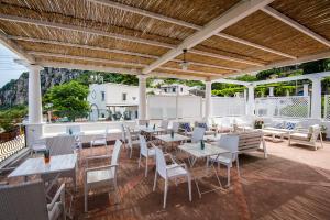 a patio area with tables, chairs and umbrellas at Villa Patrizi in Capri