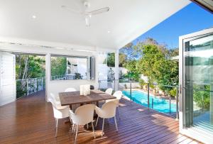 a dining room with a table and chairs and a pool at 20 Adams Street, Sunshine Beach in Noosa Heads
