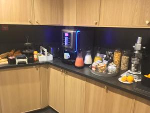 a kitchen counter with a coffee maker and some food at Hotel Alnea in Cannes