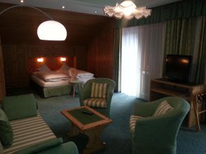 pokój hotelowy z łóżkiem, kanapą i krzesłami w obiekcie Hotel Garni Royal w Arabbie