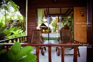 
a patio area with chairs, tables, and benches at Sand Sea Resort - SHA Extra Plus in Railay Beach
