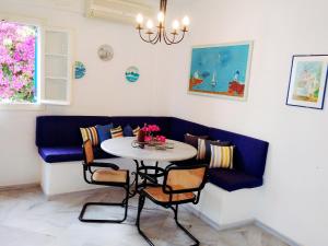 a dining room with a table and a blue couch at Villa Kavalli Paros in Prodromos Paros