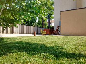 a grassy yard with a fence and a chair at Casa Kaletheia in Volpago del Montello