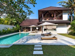 a villa with a swimming pool and a house at Villa Candi Kecil Empat in Ubud