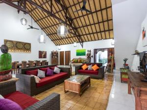 a living room with couches and a table at Villa Candi Kecil Empat in Ubud