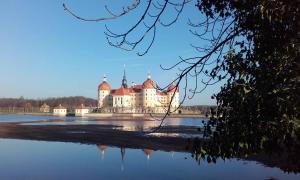 a castle sitting on top of a body of water at Ferienwohnung TOSCANA in Dresden