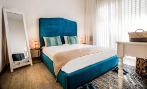 a bedroom with a large bed with a blue headboard at The Ottoman House Boutique By Domus in Beer Sheva