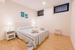 een slaapkamer met een bed met een gestreepte deken bij Apartamento Duplex La Estrella in Cádiz