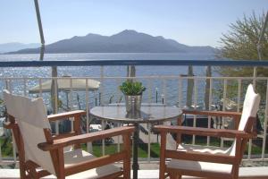 a table and chairs on a balcony with a view of the water at Glaros Studios in Loutra Edipsou