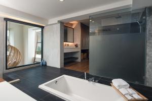 a bathroom with a tub and a large glass shower at Idyllic Concept Resort in Ko Lipe