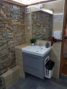 a bathroom with a sink and a stone wall at LOGE DE L'OPERA in Lyon