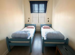 two beds in a small room with a window at Hostel Utö in Utö