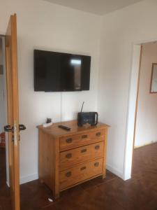 a room with a wooden dresser with a television on the wall at DG Rechts 108A 2 Zimmer Apartment Dachgeschoss in Holzminden