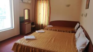 a hotel room with two beds and a mirror at Family Hotel Mimosa in Tsarevo