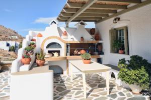 a patio with a table and potted plants on a building at The Blue Horizon Villa in Livadi +15 photos