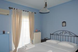 a blue bedroom with a bed and a window at The Blue Horizon Villa in Livadi