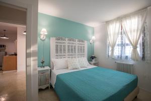 マティーノにあるAl KamarTajのベッドルーム(青と白のベッド1台、窓付)