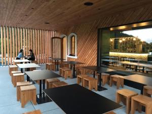 a restaurant with tables and benches and people in the background at Loučná - Apartmán Daňovi in Loučná nad Desnou