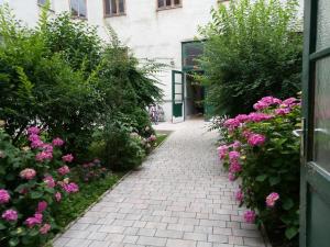 un jardín con flores rosas y una pasarela de ladrillo en Central Garden Apartments, en Viena