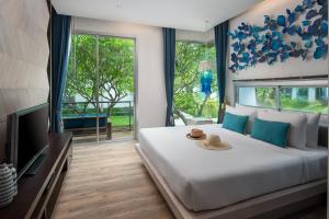a bedroom with a large bed and a television at Idyllic Concept Resort in Ko Lipe