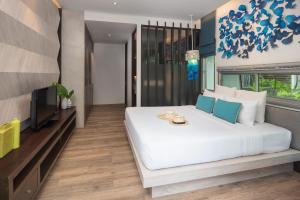 a bedroom with a large white bed and a tv at Idyllic Concept Resort in Ko Lipe