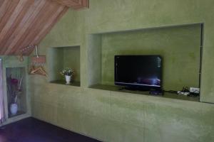 a living room with a television on a wall at Phang-nga cottage in Phangnga