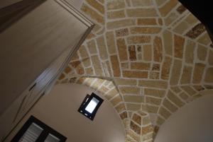 een hal met een stenen muur met een licht erop bij Casa Vacanza - Antico Attico in Monteroni di Lecce